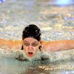 Swimmer facing forward, doing a butterfly stroke in pool