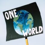 student holding up sign about changing the world
